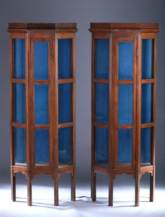 Appraisal: WALNUT GLAZED-PANEL DEMI-OCTAGON SHAPED VITRINE CABINETS Early th century with