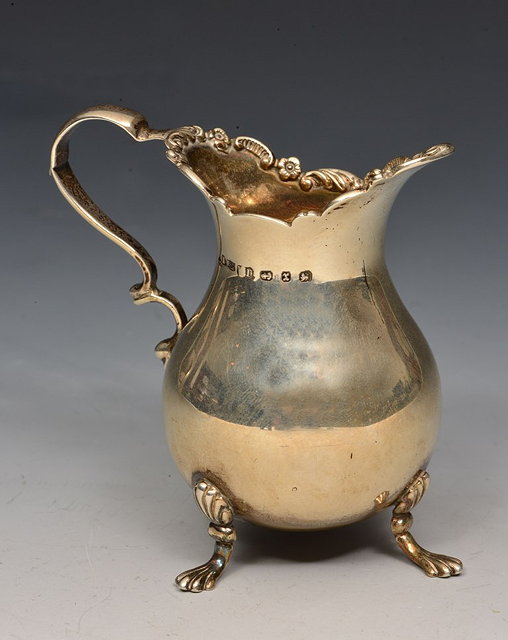 Appraisal: A GEORGIAN STYLE SILVER CREAM JUG of baluster form on