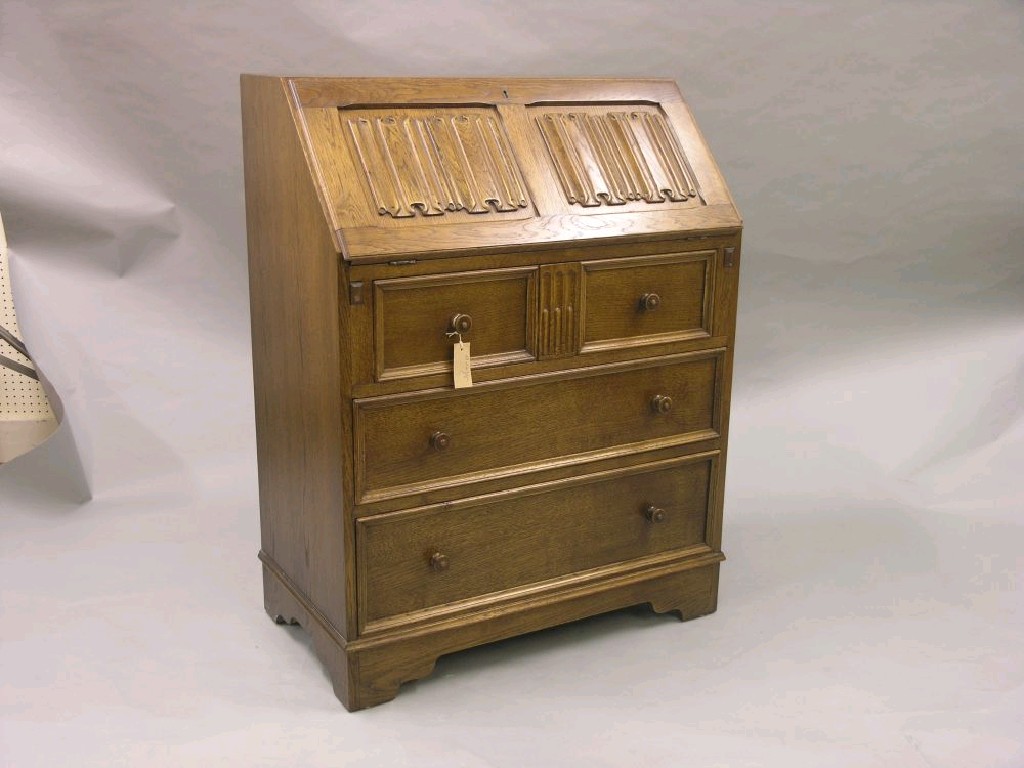 Appraisal: An oak bureau linen-fold fall front enclosing fitted interior with