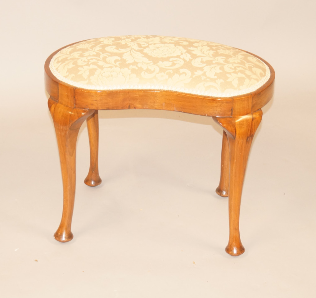 Appraisal: A walnut kidney shaped dressing stool with a padded seat