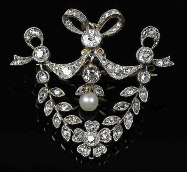 Appraisal: A diamond pendant brooch of shield shape surmounted by a