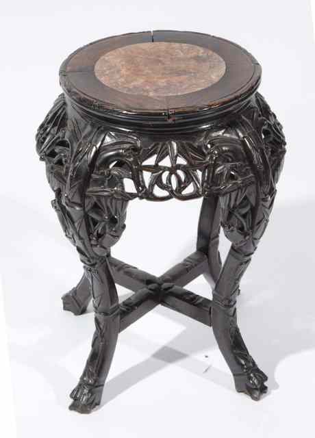 Appraisal: A CHINESE CHERRY WOOD CIRCULAR URN STAND with inset marble