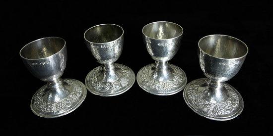 Appraisal: Four egg cups with hammered finish and borders of grapes