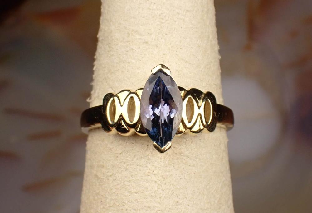 Appraisal: TANZANITE AND FOURTEEN KARAT YELLOW GOLD RING featuring a marquise-cut