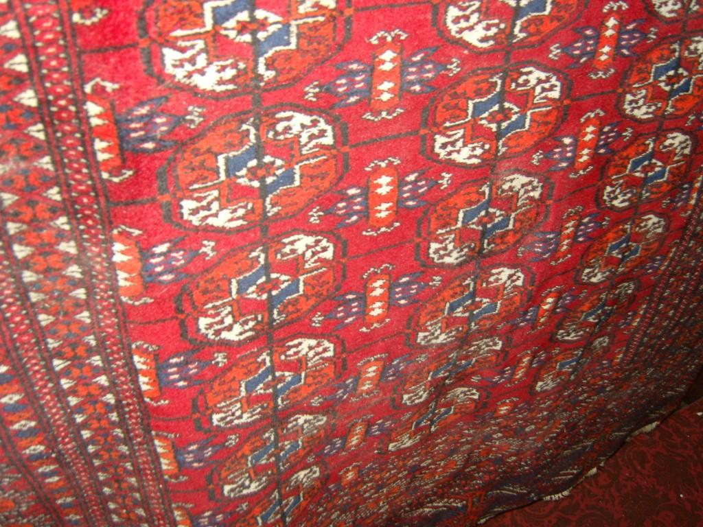 Appraisal: A red ground eastern wool rug with repeating gul motifs