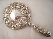 Appraisal: An ornately embossed silver backed hand mirror Birmingham