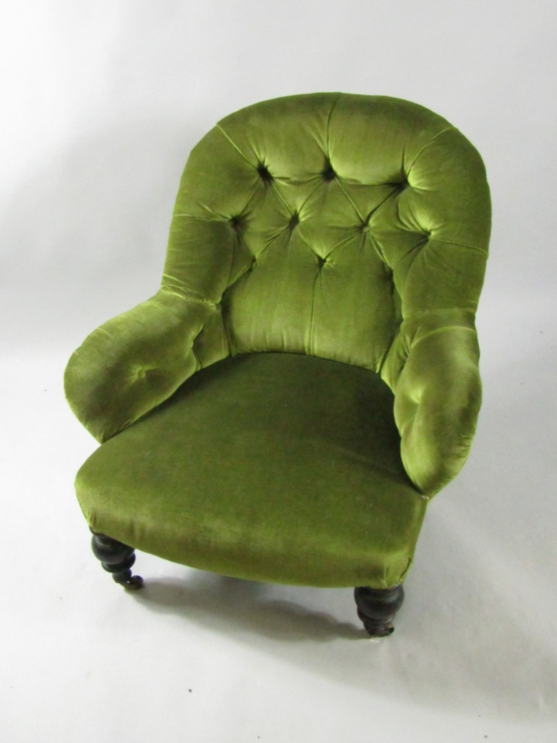 Appraisal: A Victorian ebonised nursing chair upholstered in button backed green