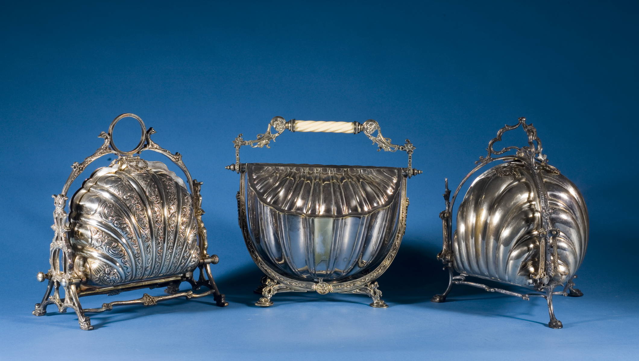 Appraisal: THREE ENGLISH SILVERPLATE SHELL-FORM COMPARTMENTED SERVING STANDS Height of tallest