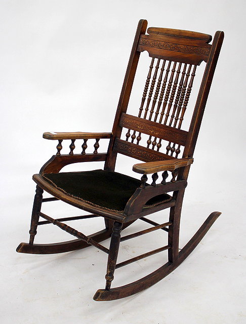 Appraisal: AN OLD AMERICAN WALNUT ROCKING CHAIR with spindle turned back