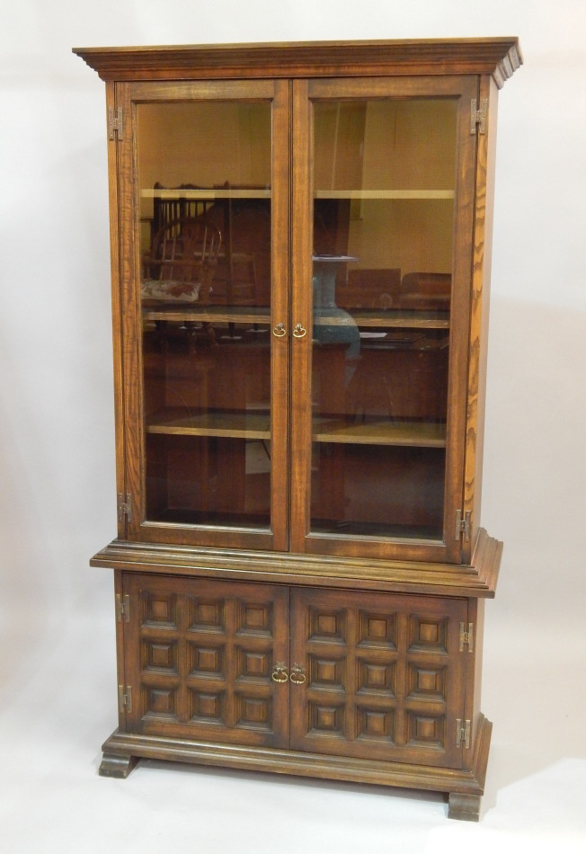 Appraisal: A modern Ercol style oak standing cabinet with two glazed