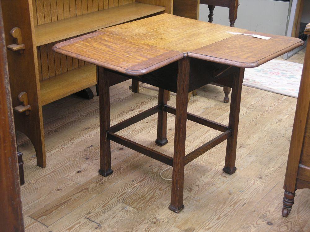 Appraisal: An unusual solid medium oak drop leaf table with four