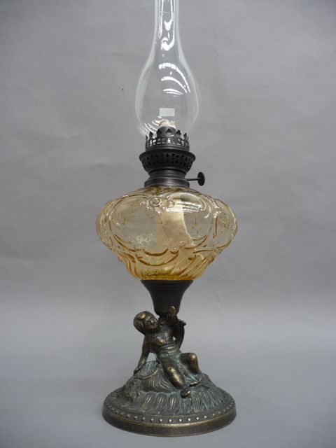 Appraisal: An oil lamp with scroll cartouche embossed glass body in