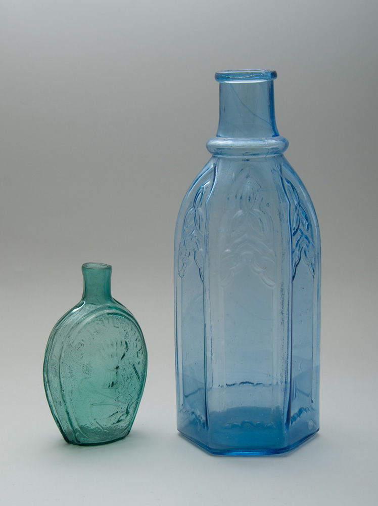 Appraisal: TWO MOLDED GLASS DECANTERS The larger pale blue of hexagonal