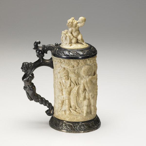 Appraisal: IVORY TANKARD With German silver mounting ornately carved with putti