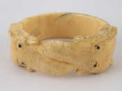 Appraisal: An ivory bangle carved as two elephants approx cm internal