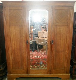 Appraisal: An Arts and Crafts silky oak wardrobe with central bevelled