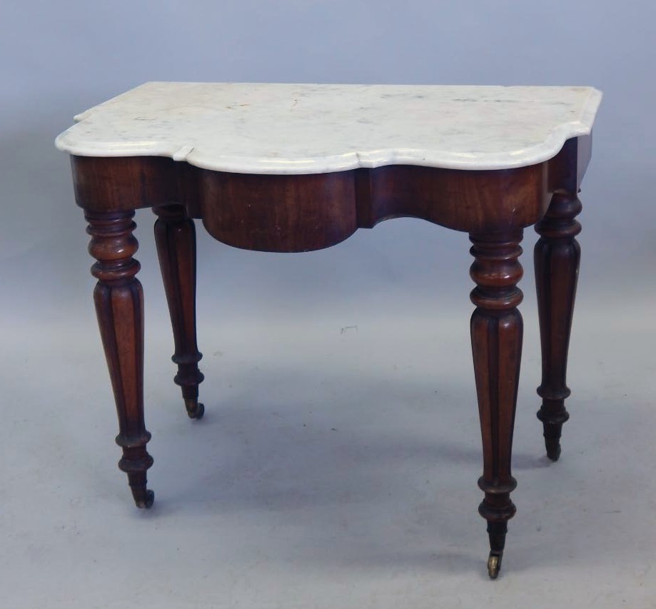 Appraisal: A Victorian mahogany washstand with a shaped white marble top