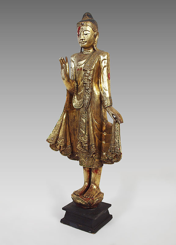 Appraisal: SILVER GILT CARVED WOOD BUDDHA Embellished with mirror dots Approx