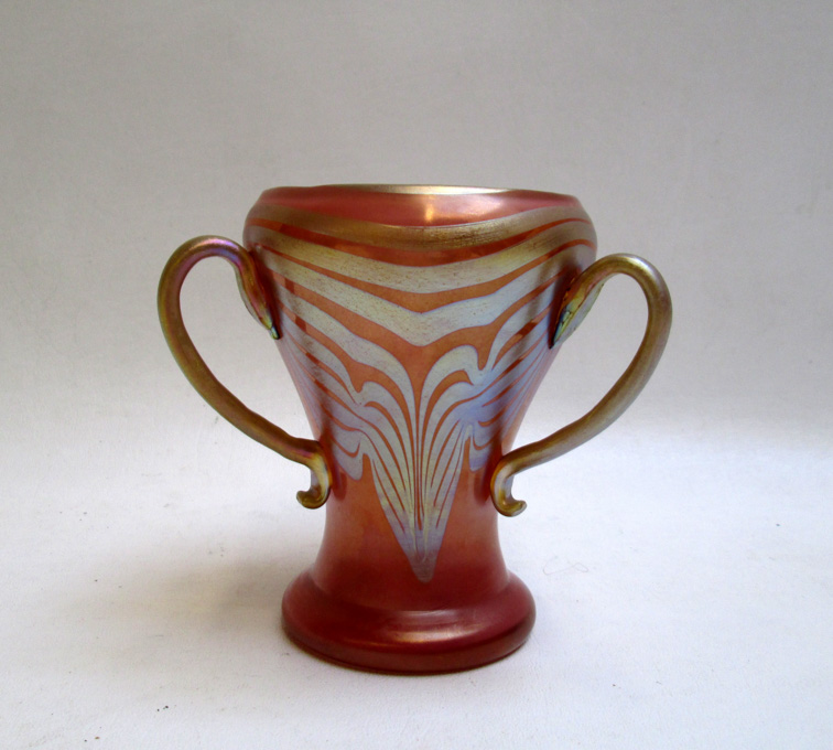 Appraisal: TRI-HANDLED ART GLASS VASE having golden iridescent design on peach