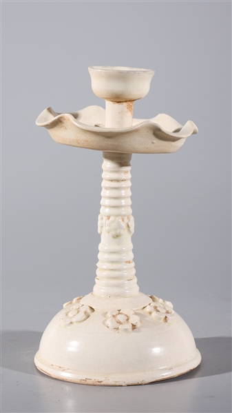 Appraisal: Chinese glazed ceramic candlestick with molded flowers to body overall