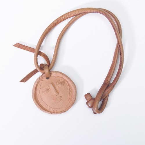 Appraisal: PICASSO MADOURA Red clay coin pendant embossed with a face