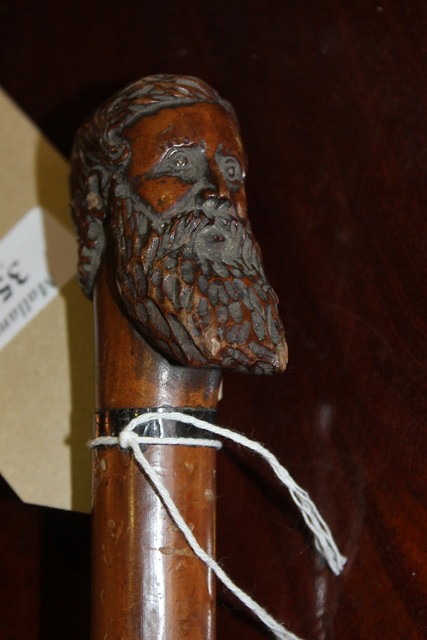 Appraisal: A HARDWOOD WALKING CANE the carved handle in the form