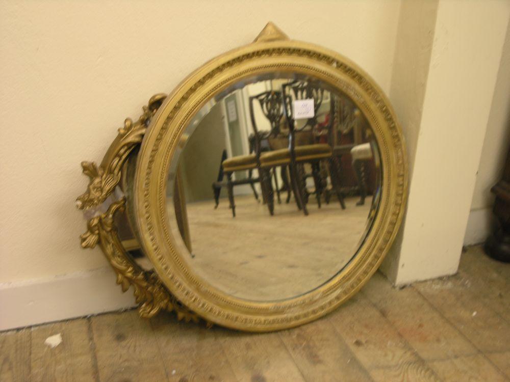 Appraisal: A circular bevelled wall mirror within egg and tongue gilt