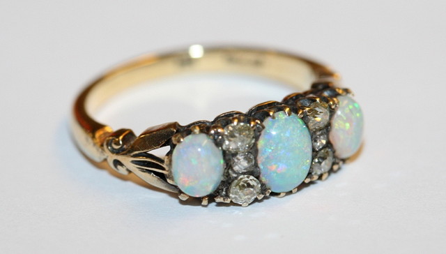 Appraisal: A THREE STONE OPAL AND DIAMOND RING graduate claw set