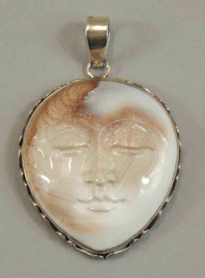 Appraisal: A silver mounted carved shell mask pendant of Shiva cm