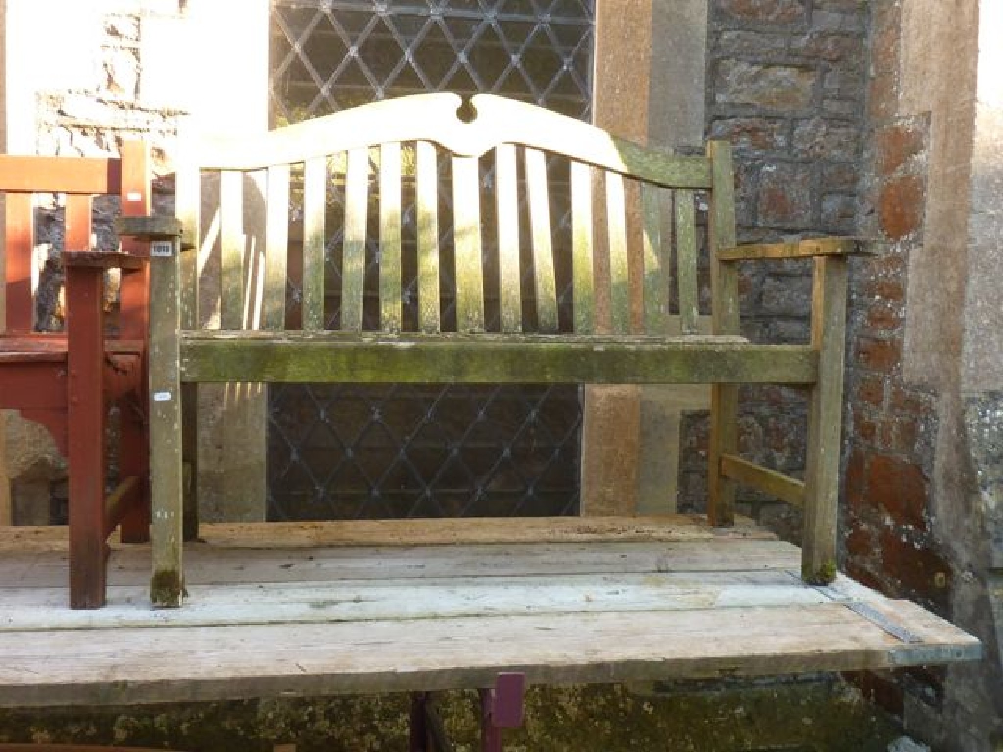 Appraisal: A weathered teak wood two seat garden bench with slatted