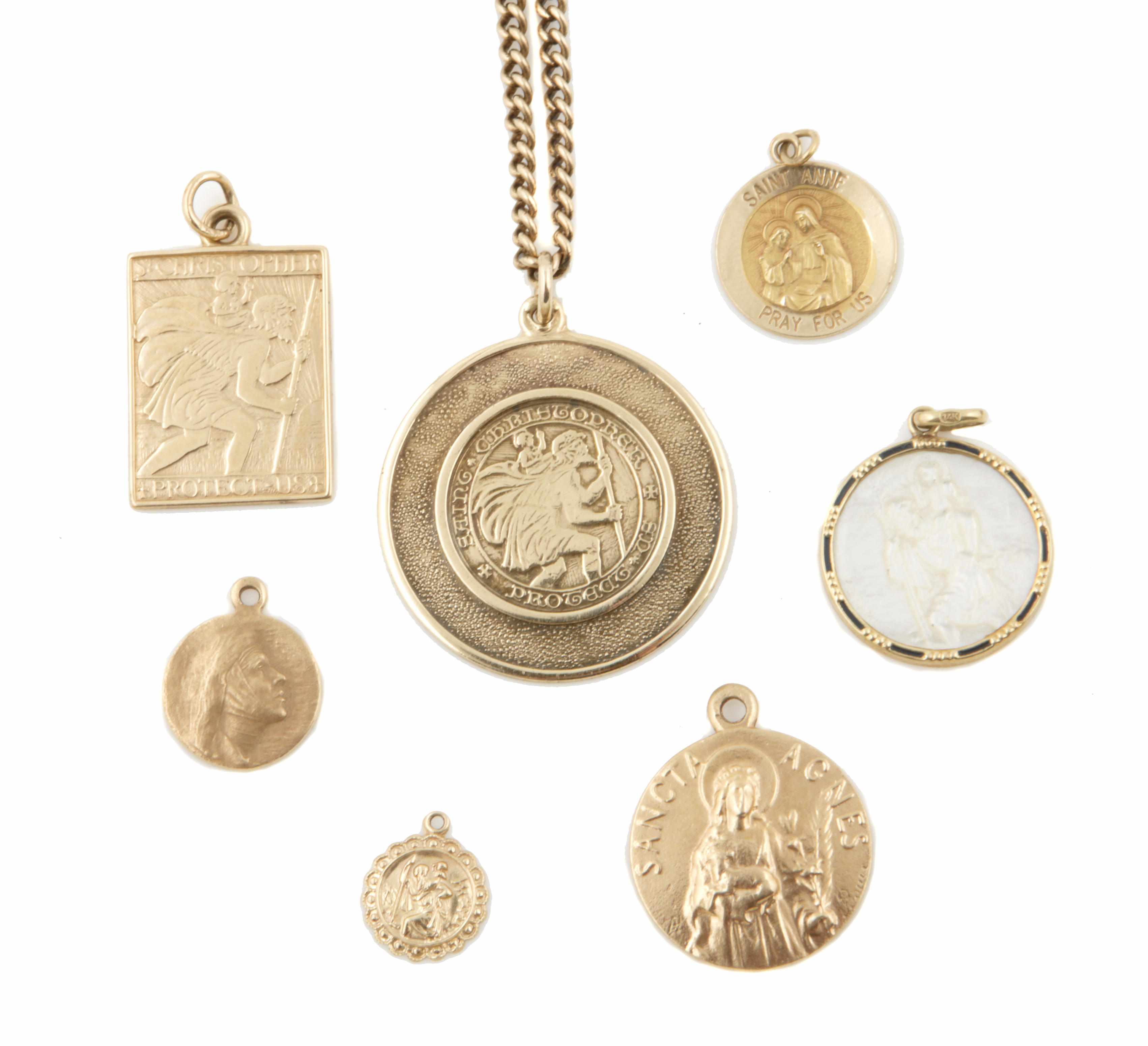 Appraisal: A collection of seven religious gold pendants with one gold-filled