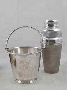 Appraisal: An engine turned silver plated cocktail shaker with lemon squeezer