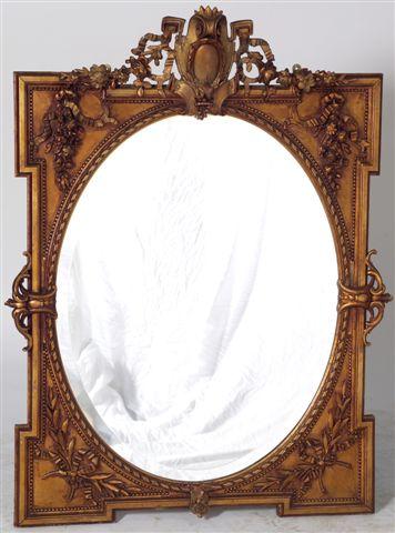 Appraisal: VICTORIAN GILT-COMPOSITION MIRROR the oval plate within a shaped rectangular