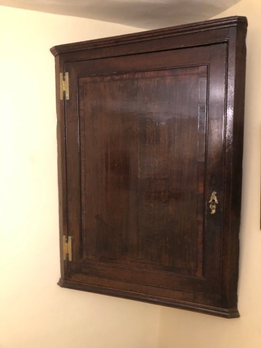 Appraisal: A George II oak hanging corner cupboard with cross banded