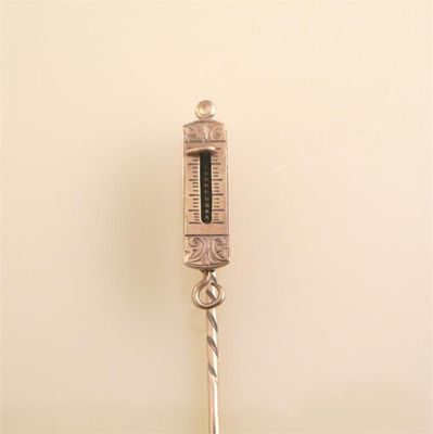 Appraisal: A gold stick pin with a miniature set of spring