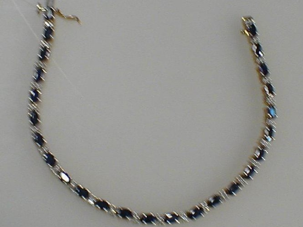 Appraisal: A diamond and sapphire set bracelet alternating oval sapphire interset