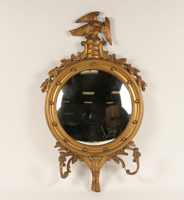 Appraisal: Gilt bullseye mirror with sconces gessoed floral trim eagle finial