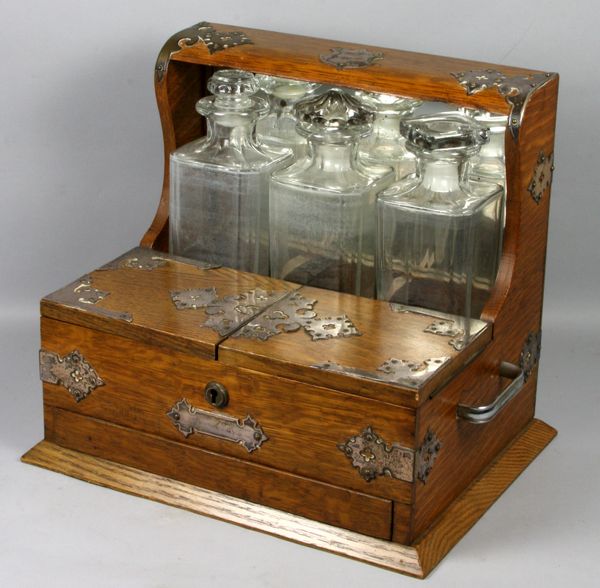 Appraisal: th Century English oak tantalus having three glass liquor bottles