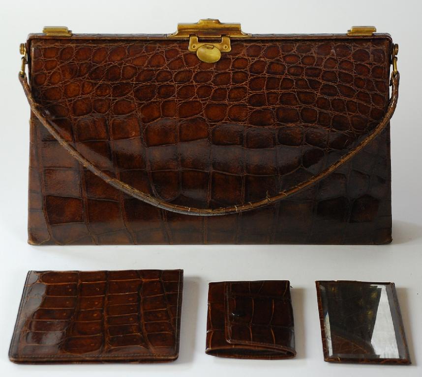 Appraisal: EARLY th CENTURY CROCODILE HANGBAG containing a crocodile MANICURE FOLDER