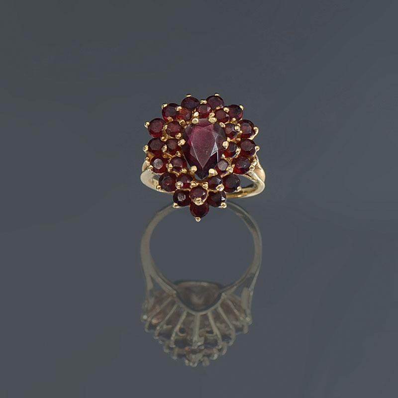 Appraisal: K GARNET RING K yellow gold ring contains pear and