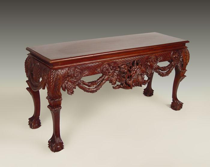 Appraisal: INDONESIAN CARVED MAHOGANY SOFA TABLE Heavy carved apron with open