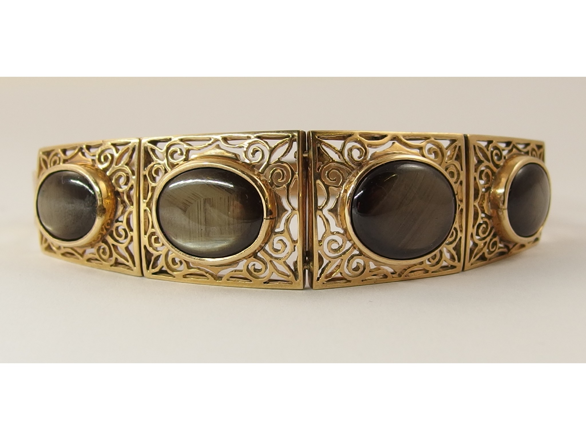 Appraisal: A decorative bracelet with four pierced scroll work panels in