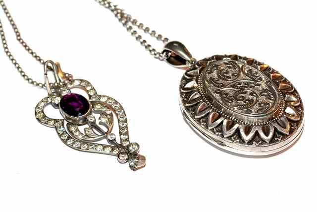 Appraisal: A VICTORIAN OVAL SILVER LOCKET with engraved scroll and leaf