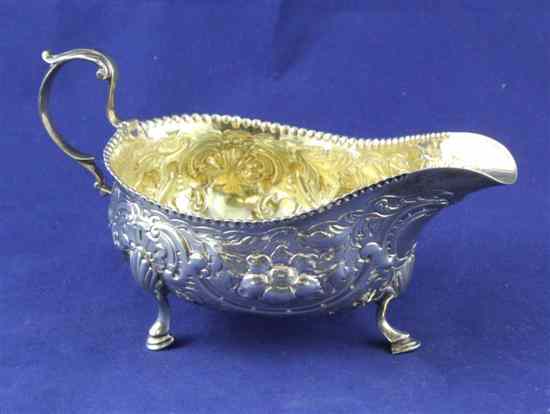 Appraisal: A George III provincial silver sauceboat with later embossed decoration