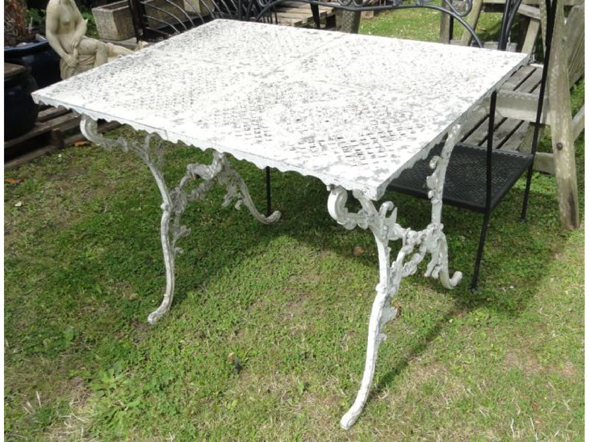 Appraisal: A cast aluminium garden table the rectangular quarter panelled top