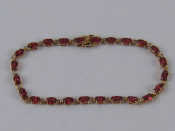 Appraisal: A yellow metal tests carat gold garnet bracelet approx cm