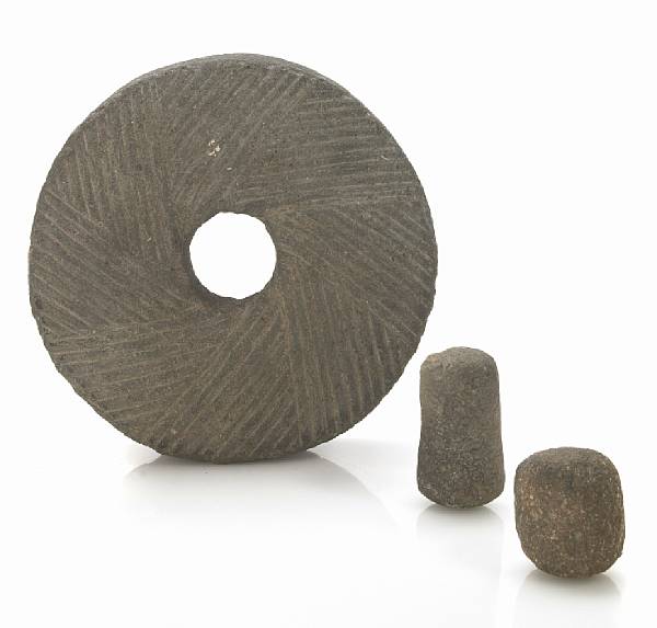 Appraisal: A carved millstone together with two pestles diameter of wheel