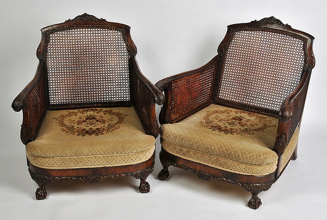 Appraisal: A PAIR OF CARVED BERGERE ARMCHAIRS each with a cane