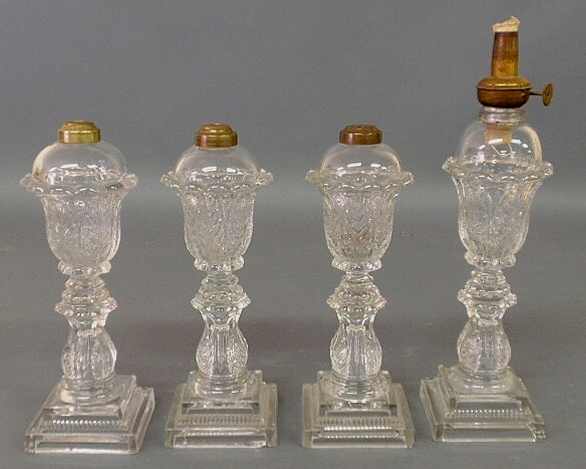 Appraisal: Four similar clear Sandwich glass fluid lamps to h