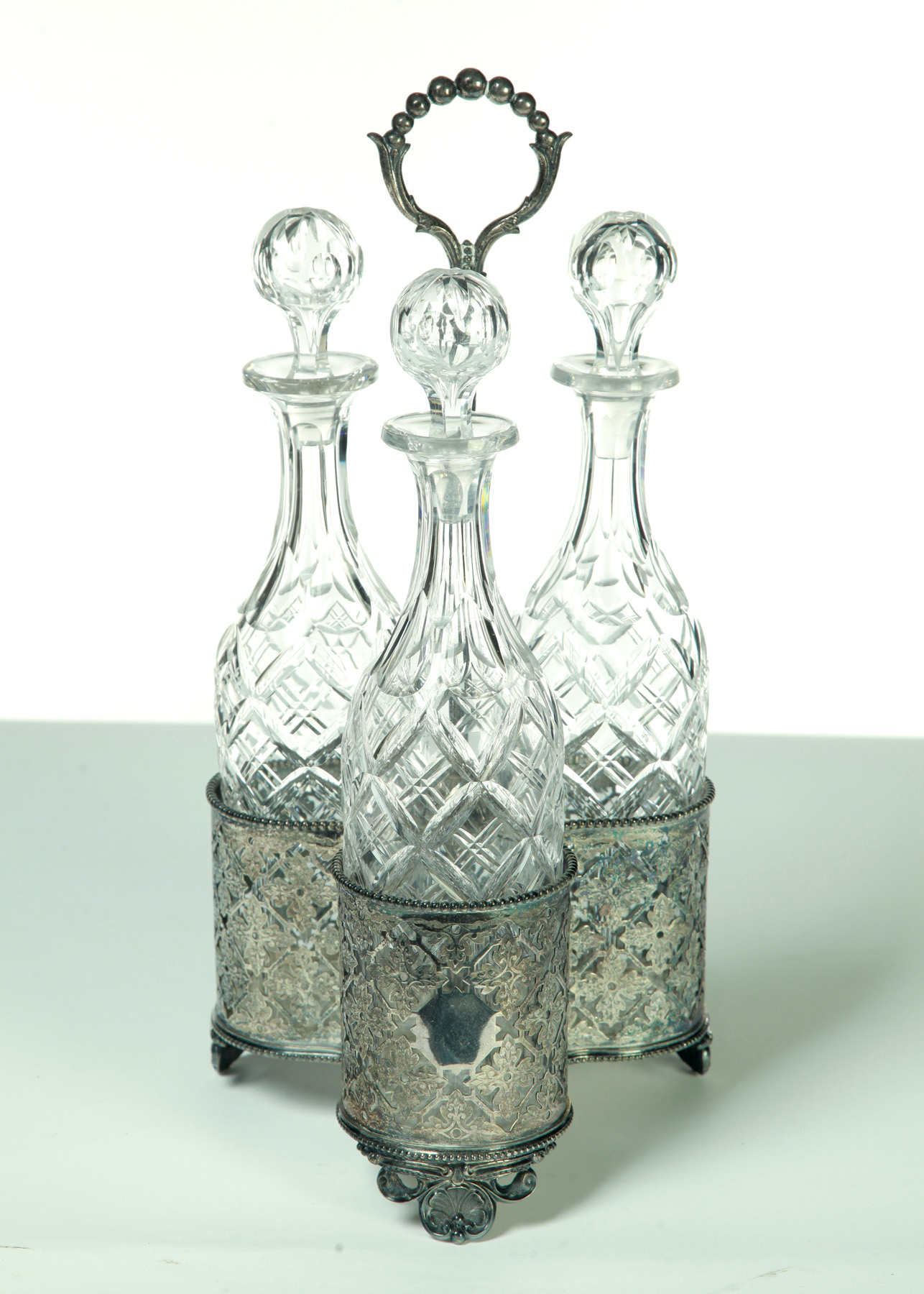 Appraisal: THREE DECANTERS IN A SILVER PLATE HOLDER England th quarter-